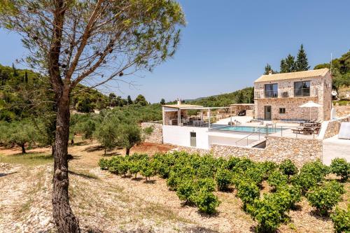 a house with a swimming pool and a tree at Misovounous Natural Park Villa by "elite" in Agios Leon