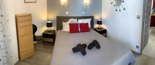 a bedroom with a bed with shoes on it at Le Rouge et Le Noir 45 m2 sur Coursives Gde Terrasse Port Nature Naturiste in Cap d'Agde