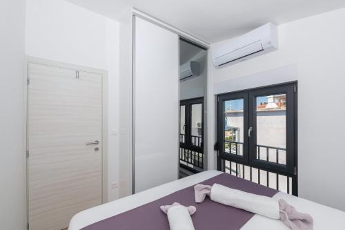 a bedroom with a bed and a balcony at Apartmani Tona in Baška Voda