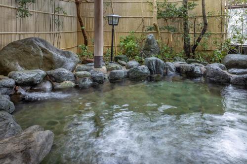 a pool of water with rocks in a backyard at Ama no Shima in Toba
