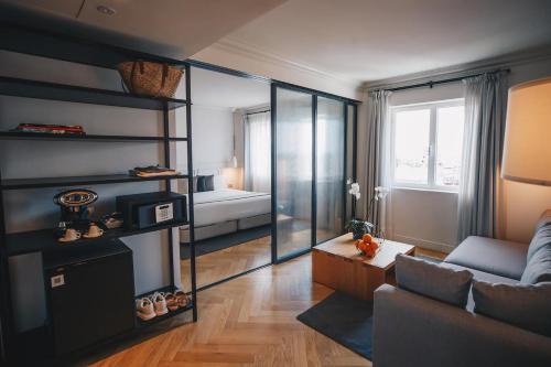 a living room with a couch and a mirror at Dear Hotel Madrid in Madrid