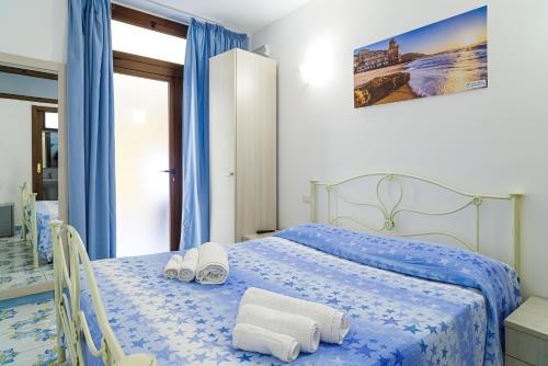 una camera da letto con un letto blu e asciugamani di Hotel La Marina a Santa Maria di Castellabate