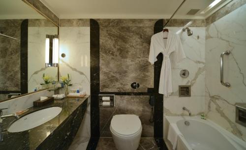 a bathroom with a sink and a toilet and a tub at Hotel Marine Plaza in Mumbai