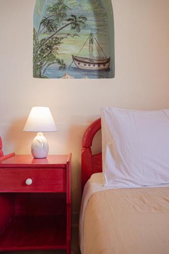 a bedroom with a bed and a table with a lamp at Elena's Seaside Apartments & Studios in Agios Gordios