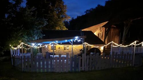 une maison avec des lumières de Noël sur une clôture blanche dans l'établissement Romantic Bijou Gite with shared pool, à Larzac