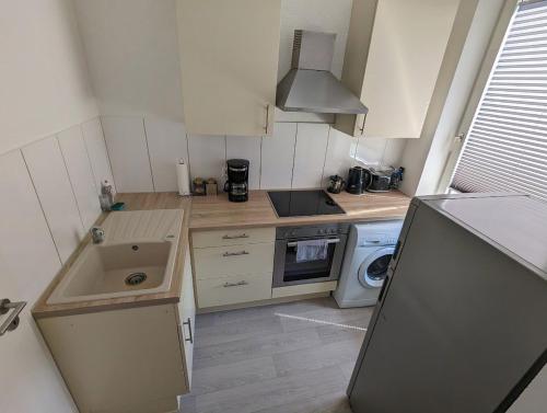 a small kitchen with a sink and a stove at Gemütliche 2-Zi-Whg, Strandnähe, kostenloser Parkplatz, Schlüsselbox, 24/7 Selfcheckin in Flensburg