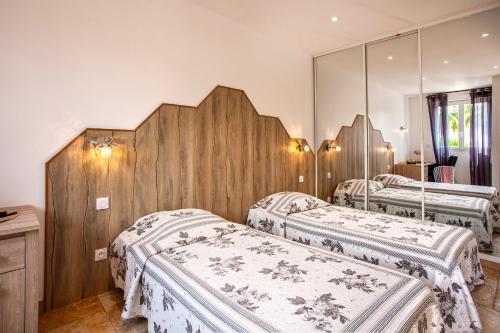 Duas camas num quarto com espelhos em U Guadellu - Piscine Chauffée em Oletta