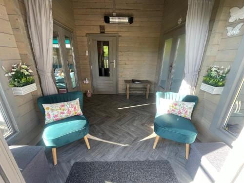 a porch with two chairs and a table at Daisy Cabin in Kincardine OʼNeil