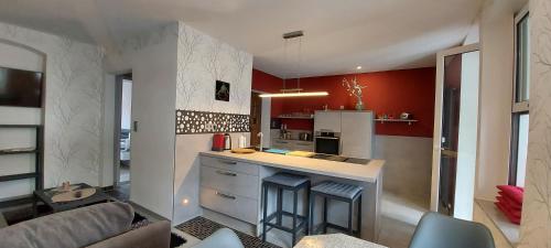 a kitchen with red walls and a counter with stools at Hochwertige Ferienwohnung/zentrumsnahe Lage! in Reichenbach im Vogtland