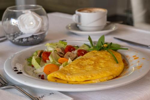 a plate of food with a omelet and a salad at The Moon Boutique Hotel & Spa in Florence