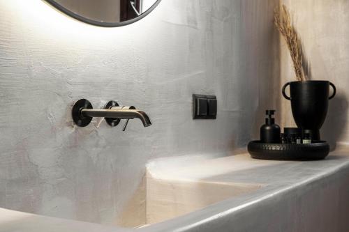 a bathroom sink with a faucet and a mirror at Agapitos Villas & Guesthouses in Agios Ioannis Pelio