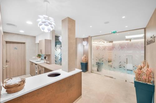 a bathroom with a sink and a large window at Danubius Hotel Bük in Bük