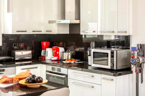 una cucina con forno a microonde e piatto di cibo di Fig Tree Bay Residences 7 a Protaras