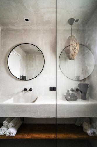 a bathroom with a sink and two mirrors at Agapitos Villas & Guesthouses in Agios Ioannis Pelio