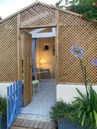 a wooden pergola with a blue gate and a patio at Charming house close to the Plage des Huttes in Chaucre