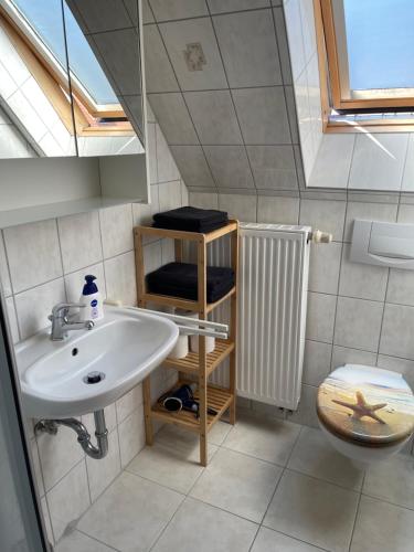 ein Bad mit einem Waschbecken und einem WC in der Unterkunft Pension Backfisch in Norden