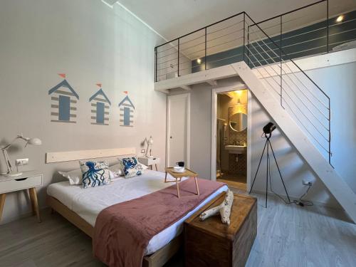 een slaapkamer met een groot bed en een trap bij Maremma Holidays : La Vecchia Officina in Follonica