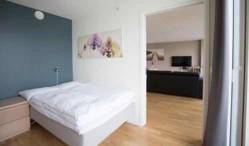 - une chambre avec un lit blanc et un mur bleu dans l'établissement Klostergaarden leilighetshotell, à Stavanger