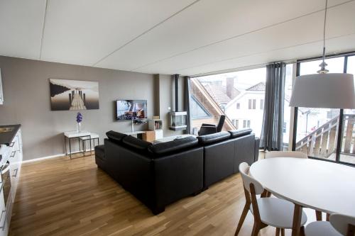 斯塔萬格的住宿－Klostergaarden leilighetshotell，客厅配有黑色沙发和桌子