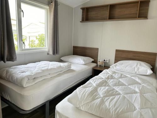 - 2 lits jumeaux dans une chambre avec fenêtre dans l'établissement Chalet 572 op Recreatiepark De Wielen, à Sint Maarten