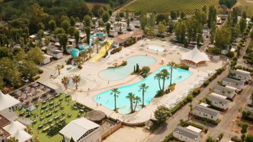 une vue aérienne d'une piscine dans un complexe hôtelier dans l'établissement Mobil home - Clim, LV, LL, TV - Camping LA CARABASSE 4 étoiles - MH-A004, à Vias