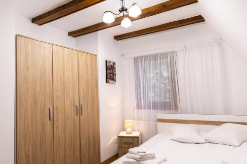 1 dormitorio con 1 cama y armario de madera en Vilele Voineasa, en Voineasa