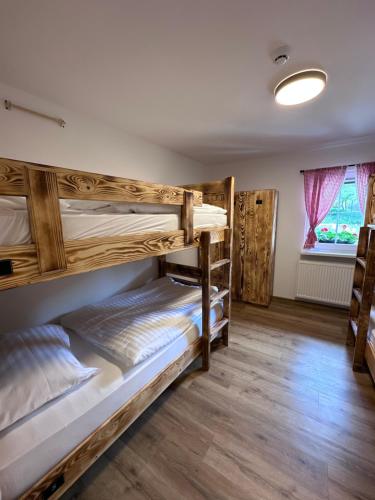 a room with two bunk beds and a window at Bajta Kroparica in Kropa