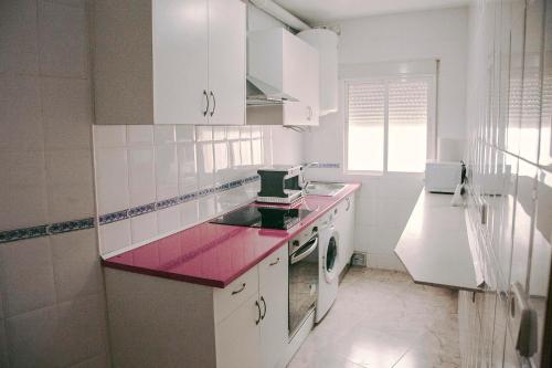 una cucina con armadi bianchi e ripiano rosa di Casa a 3 minutos del Casco y con facil aparcamiento- El rincón de Carmela a Talavera de la Reina