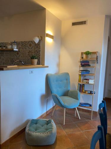 a living room with a blue chair and a book shelf at Sunshine House in Porto Pino