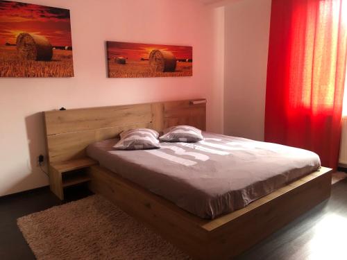 ein Schlafzimmer mit einem Holzbett und einem roten Vorhang in der Unterkunft Vibe apartament in Piatra Neamţ