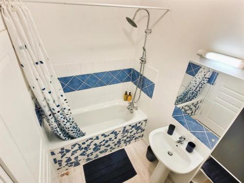 y baño con bañera blanca y lavamanos. en Le 3plex - Coeur de Vertou - Original, en Vertou