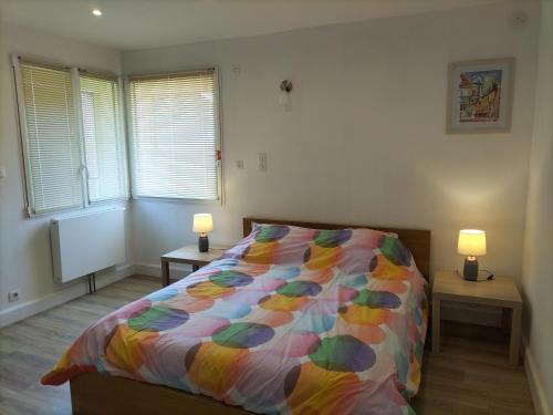 sypialnia z łóżkiem z kolorową kołdrą w obiekcie Gîte les Dames du Quint **** w mieście Baume-les-Dames