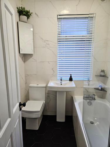 ein Badezimmer mit einem WC, einem Waschbecken und einer Badewanne in der Unterkunft Contemporary Spacious 3BR House close to City Centre in Wyken