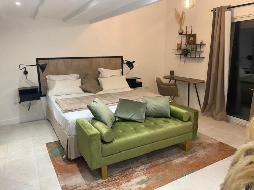 une chambre avec un lit et un canapé vert dans l'établissement Mas provençal les vanades, à Ampus