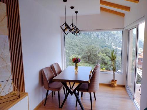 une salle à manger avec une table, des chaises et une grande fenêtre dans l'établissement Apartment Lara 3, à Kotor