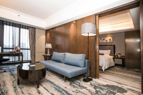 a hotel room with a blue chair and a bed at Pullman Shanghai Jing'an-Jing'an district, downtown railway station, traffic hub, easy to travel Shanghai in Shanghai