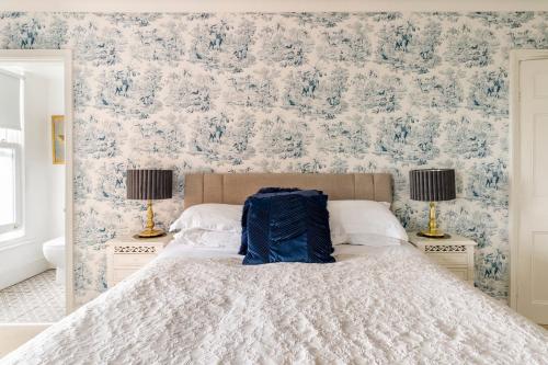 a bedroom with a large bed with blue and white wallpaper at Penyvoel Hall in Llanymynech