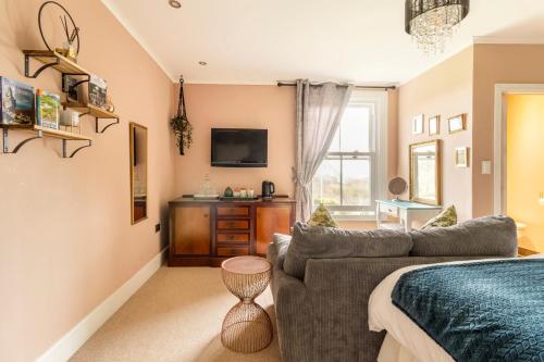 a living room with a couch and a tv at Penyvoel Hall in Llanymynech