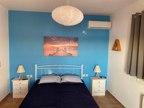 a blue bedroom with a bed and two night stands at Marys House in Porto Heli