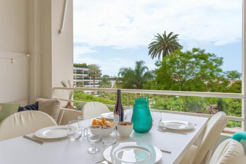 une salle à manger avec une table blanche et une grande fenêtre dans l'établissement Alma Gallia 4 pers, à Cannes
