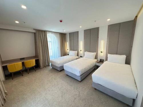 a hotel room with two beds and a projection screen at Apart Hotel Istaravshan in Tashkent