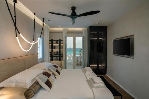 アギオス・プロコピオスにあるSea U Soon Seafront Suitesのベッドルーム1室(ベッド1台、シーリングファン付)