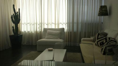 a living room with a couch and a chair and a table at Apartamento Paco in Playa del Ingles
