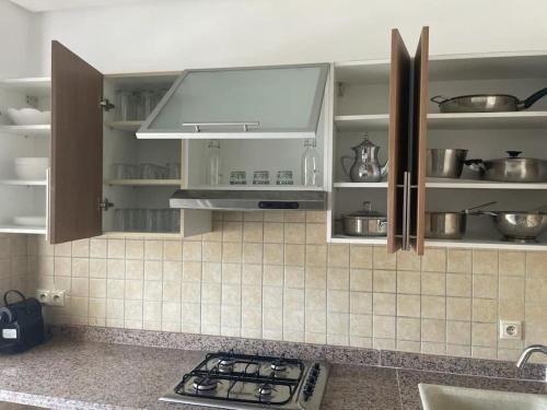 a kitchen with white cabinets and a stove top at Appartement pieds dans l’eau à sidi Rahal in Sidi Rahal