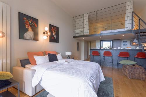 Cet appartement comprend une chambre avec un lit et une cuisine avec des chaises rouges. dans l'établissement Alma Gallia 4 pers, à Cannes