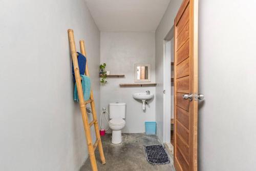 a small bathroom with a toilet and a ladder at Surfer Garden in Sanur