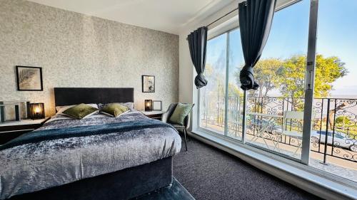 1 dormitorio con cama y ventana grande en The pacific Hotel en Clacton-on-Sea