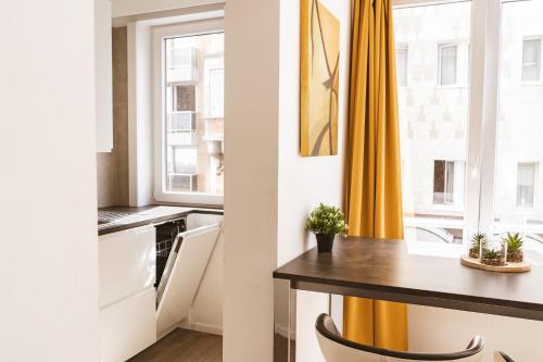 uma cozinha com uma mesa e uma cortina amarela em Silversant Zeezicht em Oostende