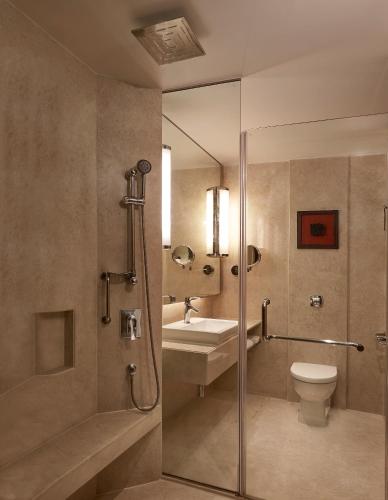 a bathroom with a shower and a toilet and a sink at Courtyard by Marriott Mumbai International Airport in Mumbai