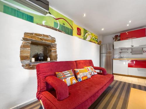 Ikaria View Resort and Villa with Pool في Arethousa: أريكة حمراء في غرفة معيشة مع مطبخ